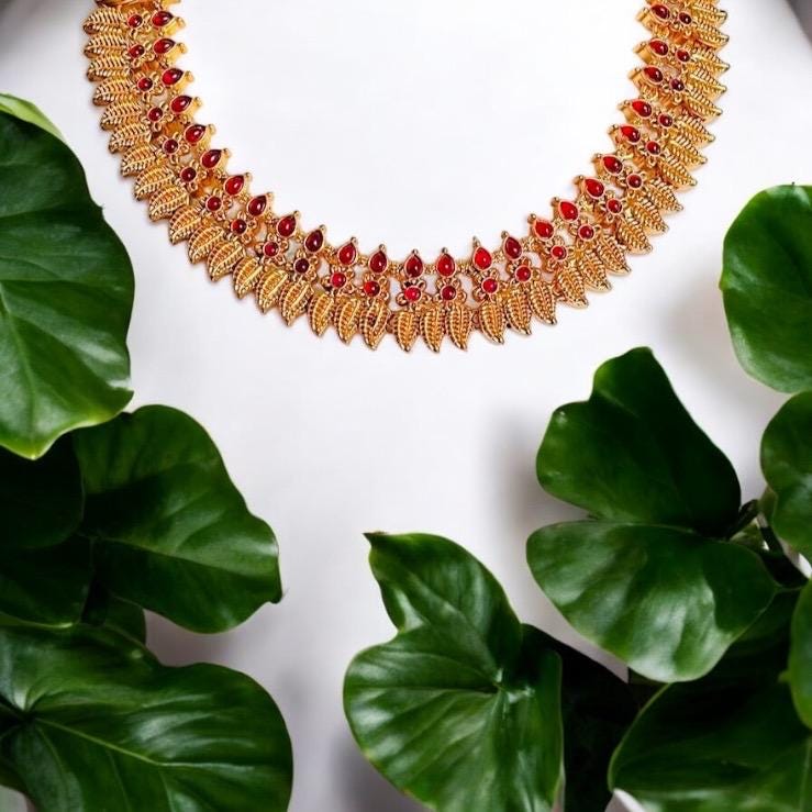 Gold toned choker necklace set with red stone